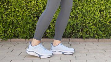 A woman is wearing light blue adaptive sneakers