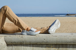 Man laying down at the beach in sandals