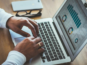 Man typing something on his computer looking at statistics
