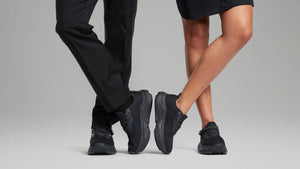 Woman and man wearing black adaptive sneakers
