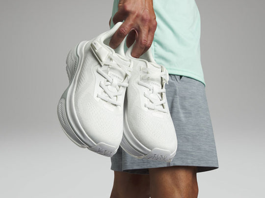 Person holding a white pair of adaptive sneakers