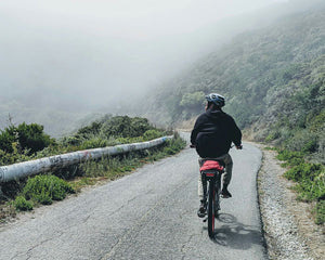 Man biking outside with helmet down a mountain road