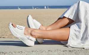 Woman wearing white sandals at the beach