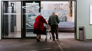 Elderly Couple walking into store with walker