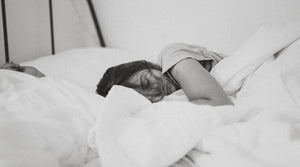 Woman sleeping in white bedding