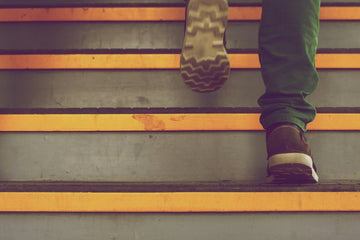 Photo of legs of a person walking up a flight of stairs