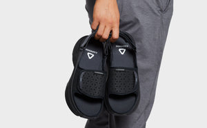 Man holding black sandals