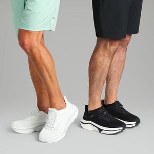 Two male models wearing black and white adaptive sneakers