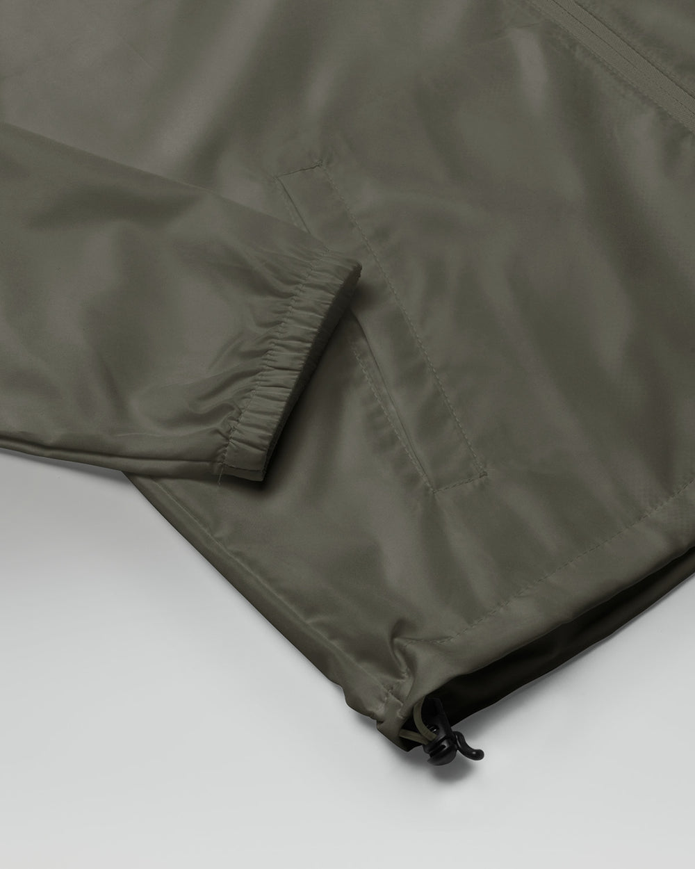 [color: graphite] Sleeve of Cadense Airwave Windbreaker on neutral background.