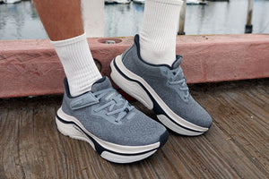 Male adult wearing grey adaptive sneakers on a pier