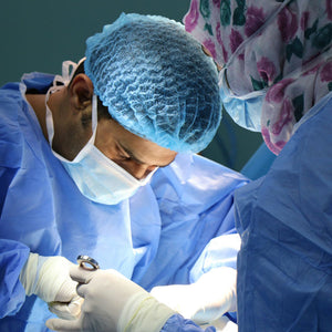 Surgeon performing surgery on person