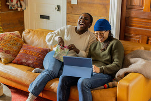 Two people sitting on a couch being happy