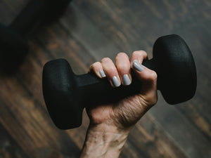 Close up photo of a hand holding a dumbbell 