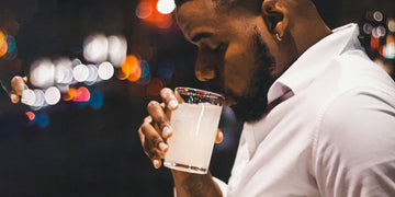 Young male adult drinking a vodka drink outside