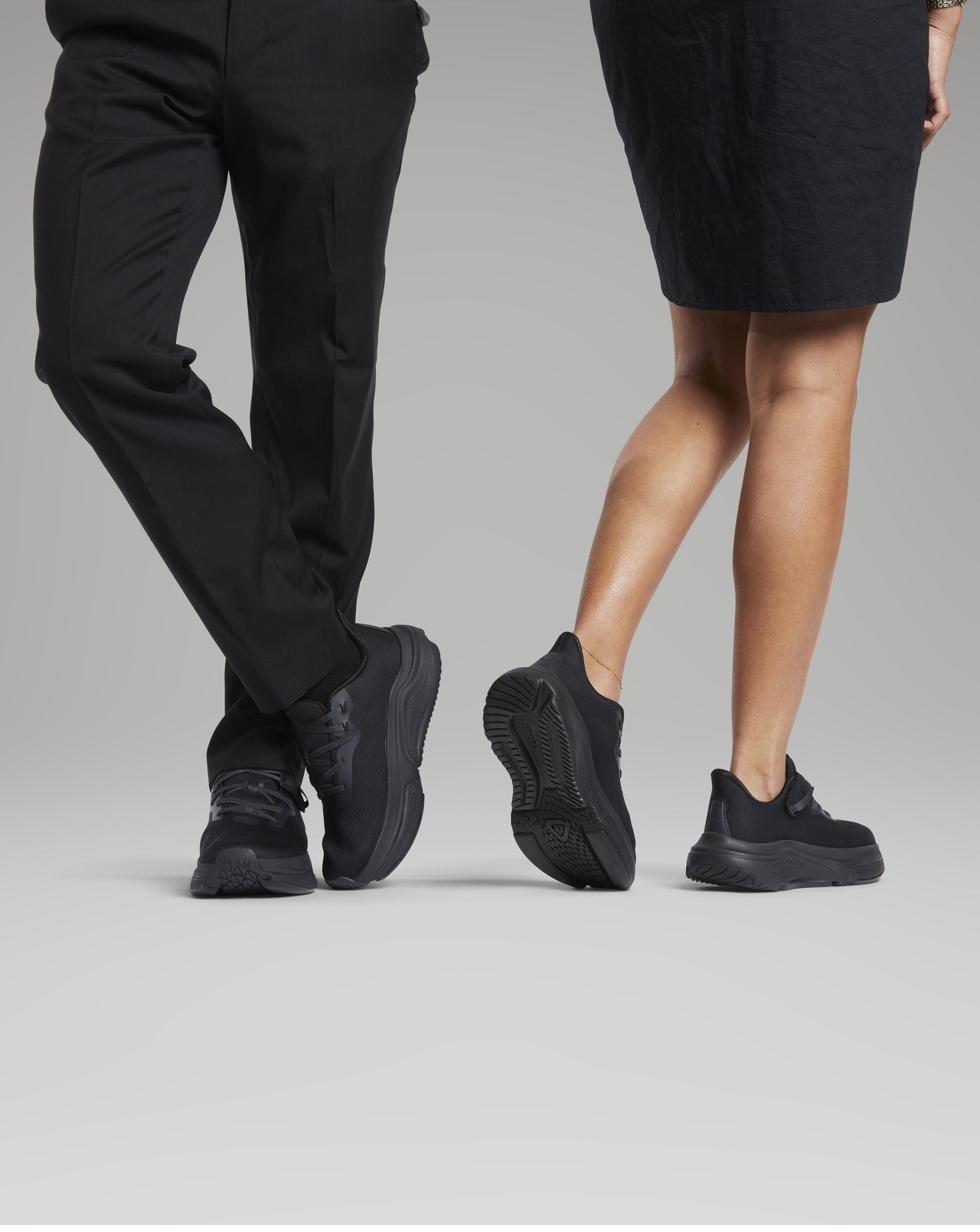 Two people wearing all-black Cadense adaptive shoes